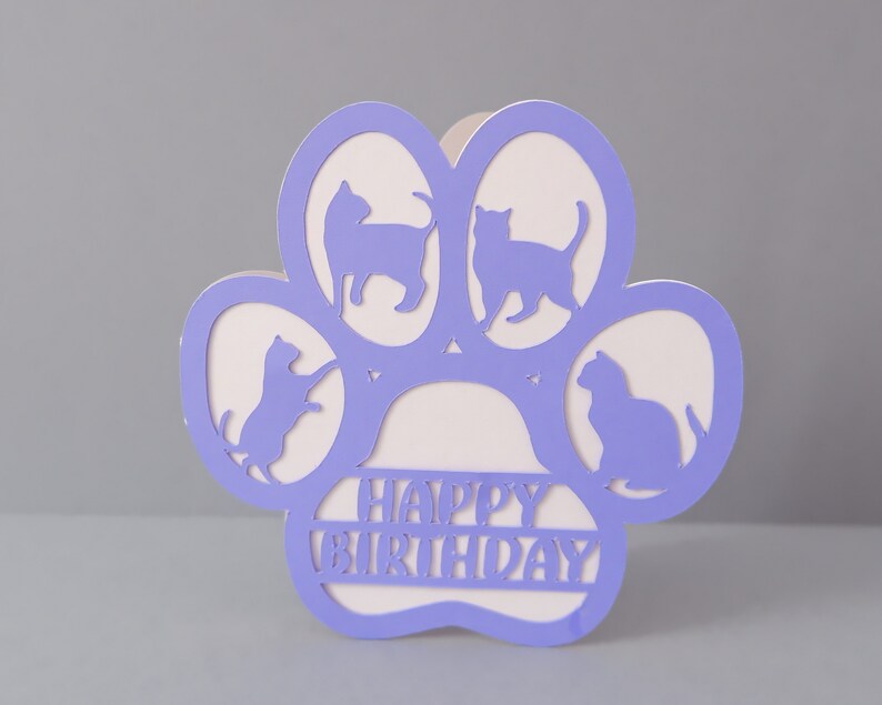 May include: Purple paw print card with four cat silhouettes and the text "Happy Birthday" inside.