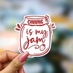 May include: Red and white sticker with a jar design and the text "Canning is my jam" with a small strawberry illustration.