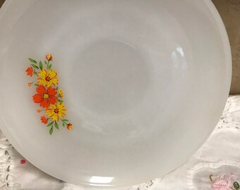 May include: White ceramic bowl with a floral design featuring orange and yellow flowers. The bowl has a frosted finish.