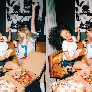 May include: Two people are enjoying pizza and wine. One person holds a slice of pizza, while the other holds a glass of red wine. They are sitting on a gold velvet couch. Pizza boxes are on the table.