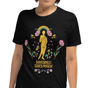 May include: Black t-shirt with a graphic design featuring a golden figure, rainbow, flowers, and mushrooms. The text "SOMETIMES I TOUCH MYSELF" is printed below the design. The shirt is made of a soft material.