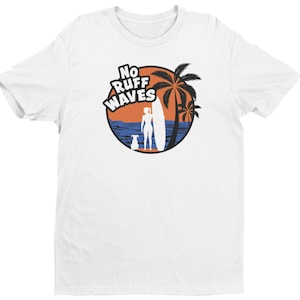 May include: A white short-sleeved t-shirt featuring a circular graphic on the chest. The design shows a silhouette of a person with a surfboard and a dog standing on a beach near palm trees, with the text NO RUFF WAVES in bold white letters.