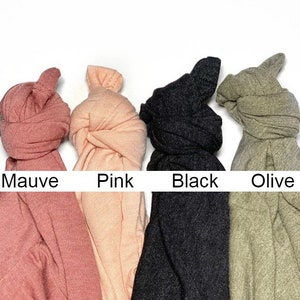 May include: Four fabric scrunchies in different colors: mauve, pink, black, and olive.