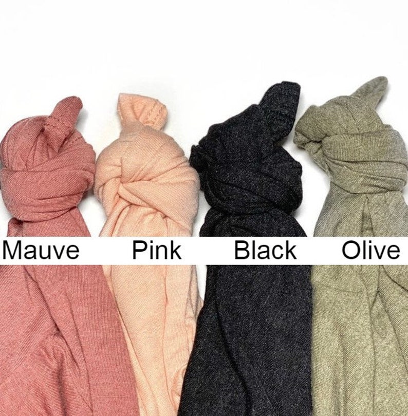 May include: Four fabric scrunchies in different colors: mauve, pink, black, and olive.