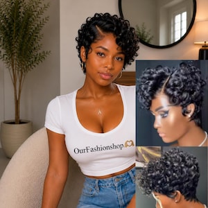 May include: A white short-sleeved crop top featuring the black text OurFashionshop with a heart-shaped hand icon. The garment has a scoop neckline and is paired with blue denim shorts. The design is shown on a person with short black curly hair.