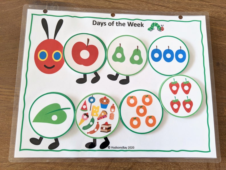 May include: A colorful educational chart featuring a caterpillar with different colored circles, each containing a different number of objects. The chart is titled "Days of the Week" and includes the text "&copy; HudsonsBay 2020".