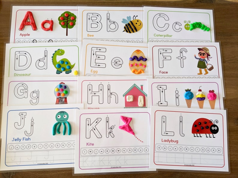 May include: A set of 12 alphabet tracing cards featuring uppercase and lowercase letters with corresponding images and words. Each card has a dotted line for tracing the letter and a space for the child to practice writing the letter.