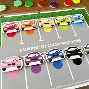 May include: A parking lot colour matching game with colourful cars and matching circles. The game includes a variety of colours, including red, orange, yellow, green, blue, purple, black, and grey. The game is designed to help children learn about colours and matching.