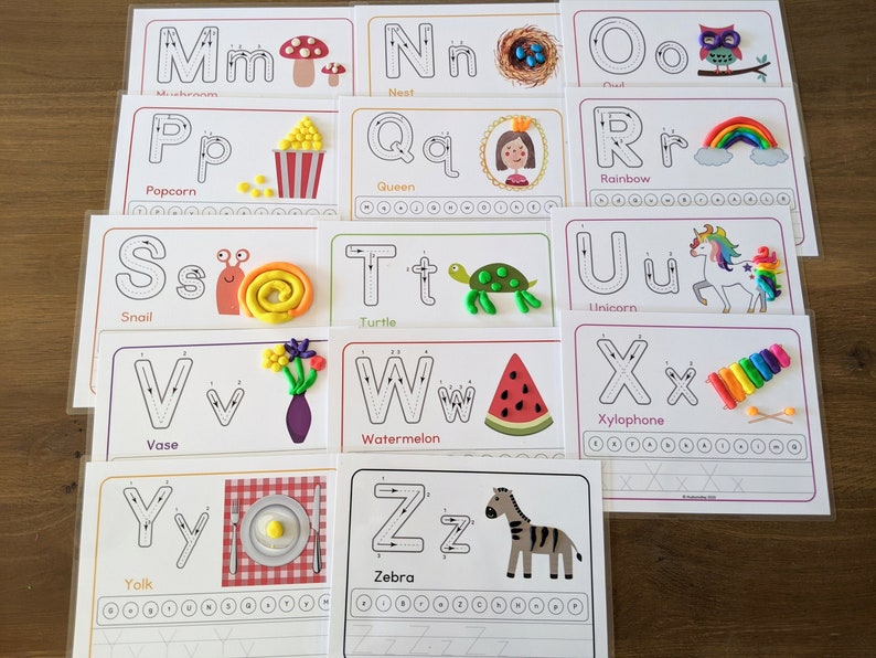 May include: A set of 26 alphabet tracing cards featuring uppercase and lowercase letters with a corresponding picture and word for each letter. The cards are printed on white cardstock and have a dotted line for tracing.