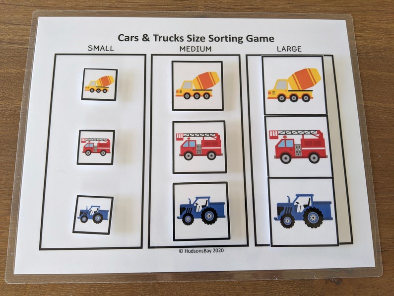 May include: A printable game for kids to sort cars and trucks by size. The game includes three sizes: small, medium, and large. The images include a yellow cement mixer, a red fire truck, and a blue tractor.