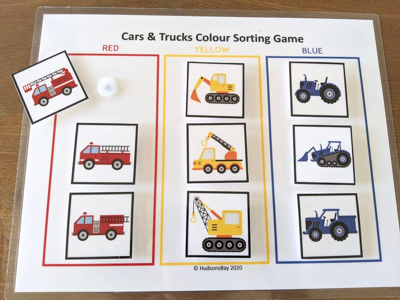 May include: A color sorting game for kids featuring red, yellow, and blue cars and trucks. The game includes a variety of vehicles, including a fire truck, a crane, and a tractor. The game is designed to help children learn about colors and shapes.