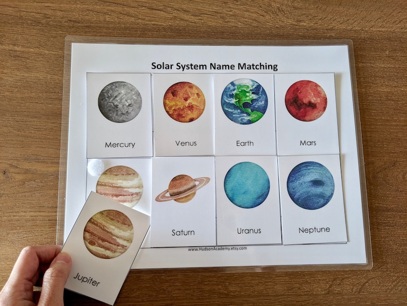 May include: A solar system name matching game with colorful illustrations of planets. The game includes cards with images of planets and corresponding names, such as Mercury, Venus, Earth, Mars, Jupiter, Saturn, Uranus, and Neptune.