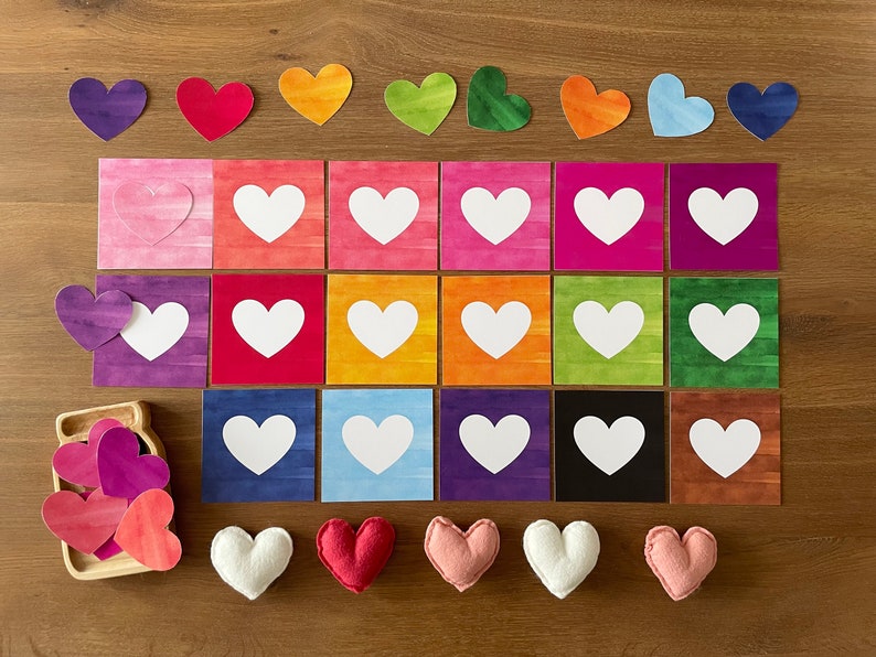 May include: A set of 18 colorful heart-shaped cards with white hearts in the center. There are also nine felt hearts in various colors, including pink, red, and white.
