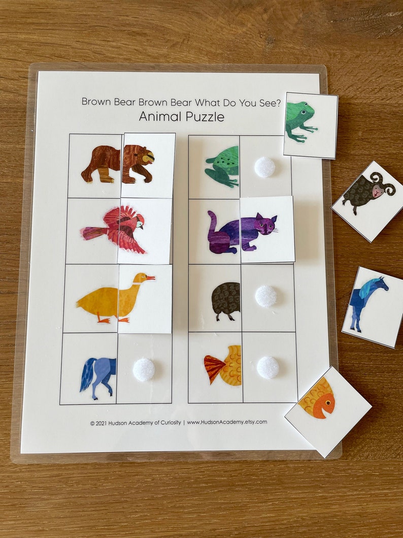May include: A brown bear, red bird, yellow duck, blue horse, purple cat, green frog, black sheep, and orange fish are pictured on a white background. The animals are part of a matching game. The text "Brown Bear Brown Bear What Do You See? Animal Puzzle" is at the top of the page.