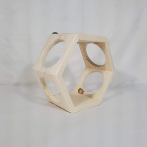 May include: A natural wood hexagonal shaped shelf with three circular openings. The shelf is made of unfinished wood and has a rustic look.