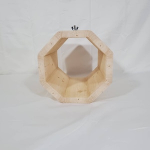 Puede incluir: Un túnel octogonal de madera para animales pequeños. El túnel está hecho de madera natural y tiene un acabado liso. Tiene un diámetro de aproximadamente 20 cm y una longitud de 30 cm.