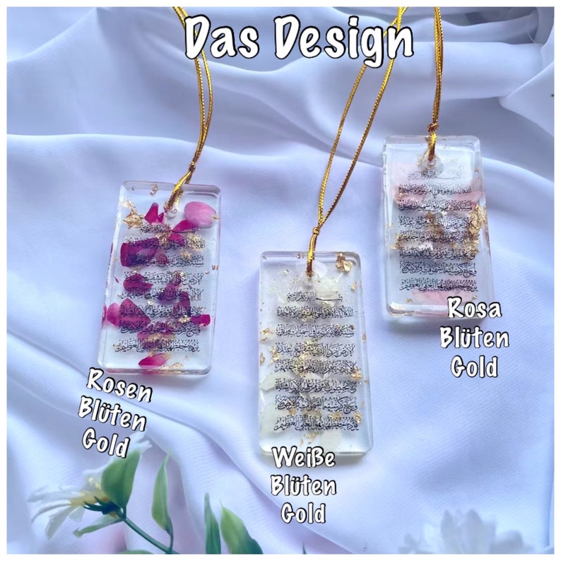 May include: Three rectangular resin pendants with gold cords. The pendants contain text, dried flowers, and gold flakes. The text is in Arabic script. The pendants are labelled "Rosen Bl&uuml;ten Gold", "Wei&szlig;e Bl&uuml;ten Gold", and "Rosa Bl&uuml;ten Gold".