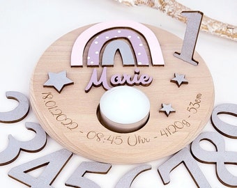 Peut inclure: Un porte-bougie d'anniversaire en bois avec un motif arc-en-ciel, le nom "Marie" et la date "18.01.2022 - 08:45 Uhr - 4120g - 53cm". Le porte-bougie a un espace pour une bougie au centre et est livré avec les chiffres de 1 à 9.