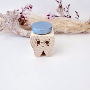 May include: A wooden tooth with a smiling face, wearing glasses and a blue top hat. The tooth is a decorative object.