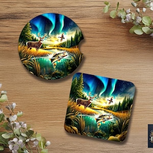 Peut inclure: Deux dessous de verre avec une scène de nature représentant un cerf, des poissons et des oiseaux sous une aurore boréale vibrante. Un dessous de verre est rond, l'autre carré. Les dessous de verre sont sur une surface en bois.