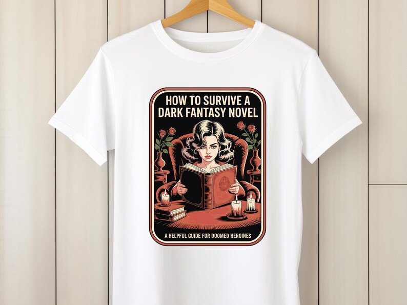 A white t-shirt with a graphic design depicting a woman reading a book, surrounded by various objects such as candles, vases, and a potted plant.
