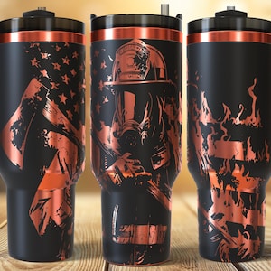 May include: Black insulated travel mugs with copper-coloured designs. One features an American flag, another a firefighter, and the third flames. Each mug has a black handle and lid.