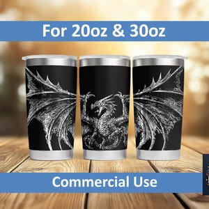 Può includere: Tre bicchieri in acciaio inossidabile neri con un design ad ali di drago bianche. I bicchieri hanno un bordo e una base argentati. Il testo "For 20oz & 30oz" e "Commercial Use" sono visualizzati sull'immagine.