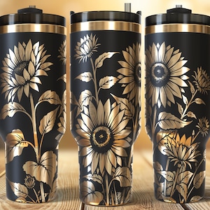May include: Three black travel mugs with gold sunflower designs. Each mug has a black handle, lid, and gold trim. The sunflower design includes detailed petals, leaves, and stems. The mugs are displayed on a wooden surface.