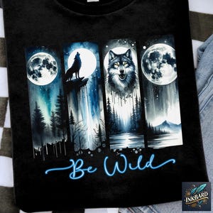 May include: Black t-shirt with a watercolor design of four wolves howling at the moon. The design is in shades of blue and white. The text "Be Wild" is written in blue below the wolves.