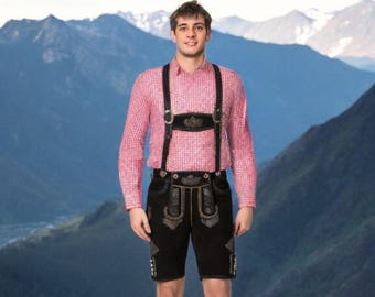 May include: A man wearing a pink and white checkered shirt with black suspenders and black leather lederhosen. The lederhosen have gold embroidery and a black leather belt.