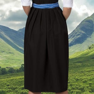 May include: A black dirndl skirt with a blue ribbon waistband. The skirt is pleated and has a simple design.