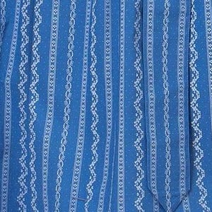 May include: Blue fabric with a white patterned design. The pattern features vertical stripes with a repeating design of small dots and a wavy line.