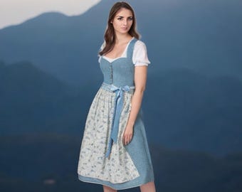 Peut inclure: Une robe traditionnelle bavaroise de couleur bleu clair avec une jupe à imprimé floral blanc et bleu et un corsage bleu clair. Le corsage est orné d'une dentelle blanche et d'un ruban bleu noué à la taille.