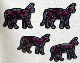 May include: Four black cat skeleton stickers with pink and blue outlines. The cats are in a walking pose.