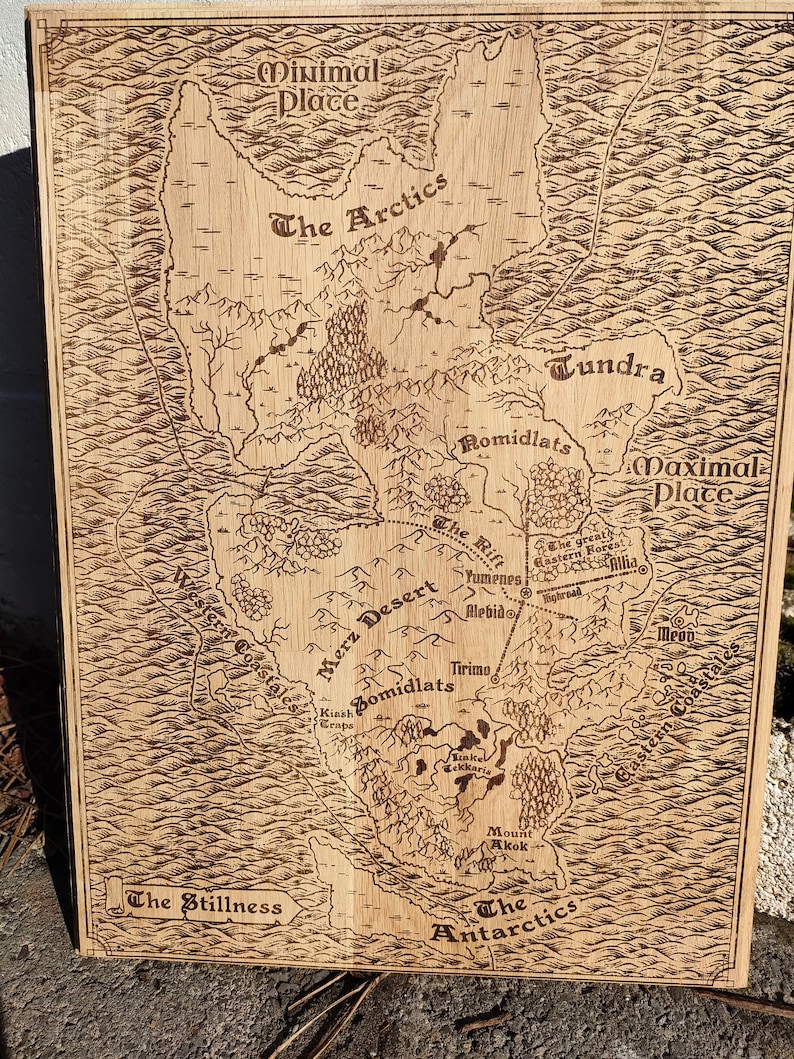 May include: A wood-burned map depicting a fantasy world.  The map features various geographical locations, including The Arctics, Tundra, Merz Desert, Romidlats, and Maximal Place.  Names of locations are clearly labeled.  The map is rectangular and has a light brown wood grain texture. The ocean is represented by wavy lines. The overall style is reminiscent of an antique map.