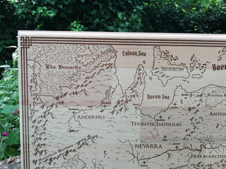 May include: Light brown wooden laser-engraved fantasy map featuring various regions, seas, and mountain ranges.  The Donarks, Ander Fels, Tevinter Imperium, and Nevarra are among the labeled regions.  The Colean Sea and Rocen Sea are also depicted.  The map's border is accented with a decorative frame.  The style evokes classic fantasy game maps.