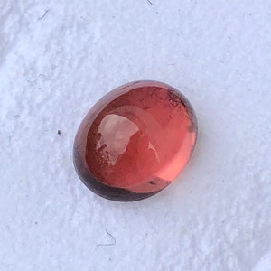 Natural orange tourmaline cabochon semiprecious gemstone in oval shape from africa