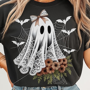 Może przedstawiać: Czarny t-shirt z białym wzorem ducha z koronkowym wykończeniem, brązową kokardą i bukietem kwiat&oacute;w. Projekt zawiera nietoperze i pajęczyny, idealny na Halloween. Widoczny jest tekst "DIGITAL DOWNLOAD".