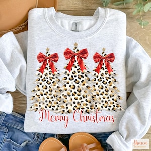 May include: A gray sweatshirt with a design of three leopard print Christmas trees with red bows and the text "Merry Christmas" in red.