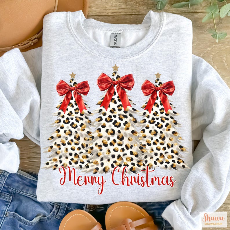 May include: A gray sweatshirt with a design of three leopard print Christmas trees with red bows and the text "Merry Christmas" in red.