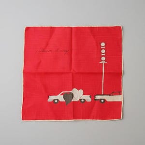 Könnte beinhalten: Rotes Taschentuch mit cremefarbenem Rand. Das Design zeigt zwei Autos, eine Ampel und zwei Herzen. Der Text "¡Atención al rojo!" steht in der oberen linken Ecke.