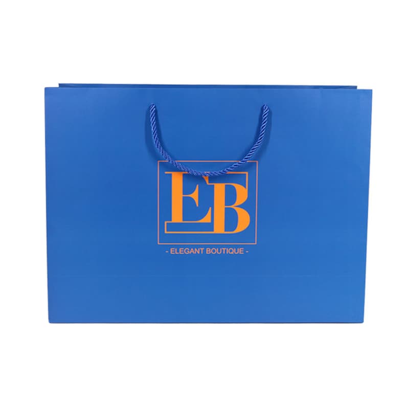 May include: A blue shopping bag with a rope handle. The bag features the orange letters "EB" inside a rectangular frame, with the words "ELEGANT BOUTIQUE" below.