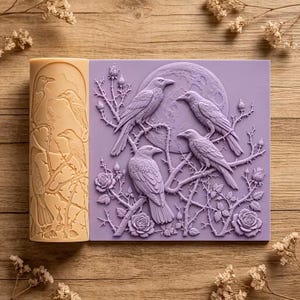 May include: A rectangular lavender silicone mold and a cylindrical beige silicone mold, both featuring embossed designs of ravens perched on thorny rose branches with a full moon background, intended for crafting and decorative casting projects.