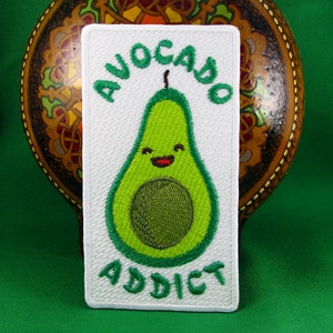 May include: White embroidered patch with a green avocado illustration and the text "AVOCADO ADDICT".