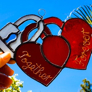 May include: Two red glass hearts with gold lettering. One heart says "Together" and the other says "Forever".