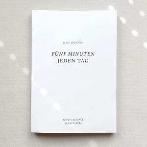 Puede incluir: Un diario blanco con el título "Fünf Minuten Jeden Tag" y el subtítulo "Motivation & Selbstliebe".