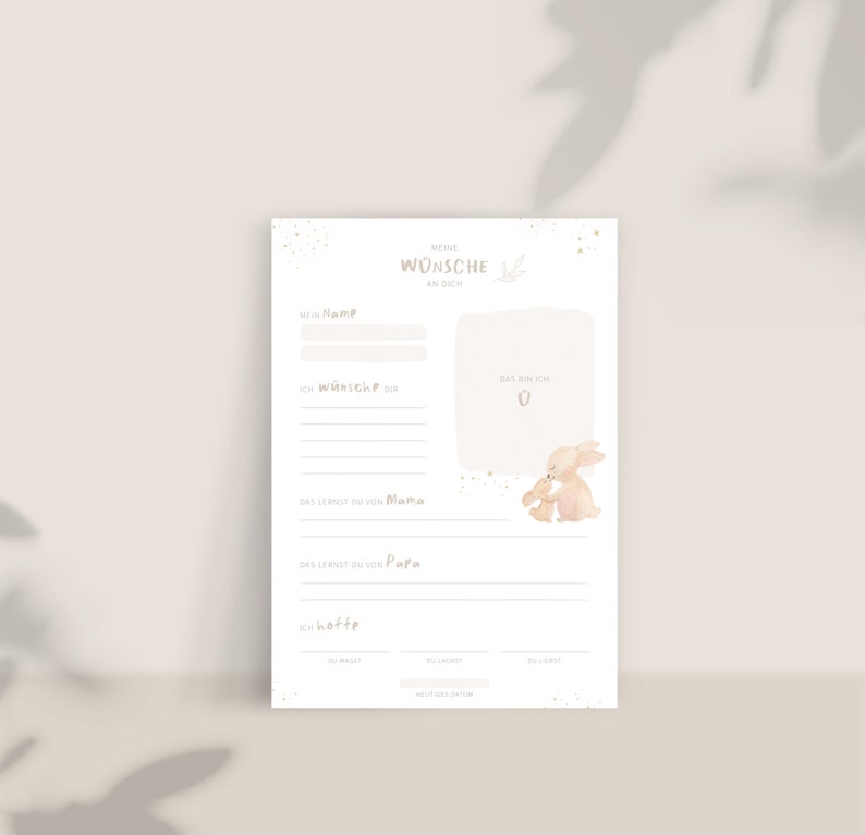 May include: A printable baby shower or new baby gift card with a watercolor illustration of two bunnies. The card has spaces to write the baby's name, wishes for the baby, what the baby will learn from mom and dad, and hopes for the baby's future. The card has the text "Meine W&uuml;nsche an dich" which translates to "My wishes for you".