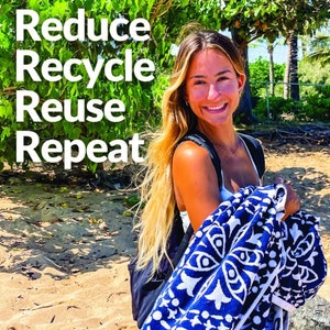 May include: A woman with long blonde hair is standing on a beach holding a blue and white patterned towel. The text "Reduce Recycle Reuse Repeat" is visible in the background.