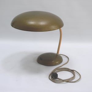 Könnte beinhalten: Vintage Schreibtischlampe mit einem gewölbten, olivgrünen Schirm und passendem Sockel. Der gebogene Arm ist hellbraun. Die Lampe hat ein Kabel und einen Stecker. Das Design ist modern aus der Mitte des Jahrhunderts. Höhe ca. 30 cm.