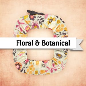 May include: A floral and botanical themed item with a light blue background. The item has a repeating pattern of flowers in shades of yellow, orange, pink, and brown. The text "Floral & Botanical" is displayed on a white banner.